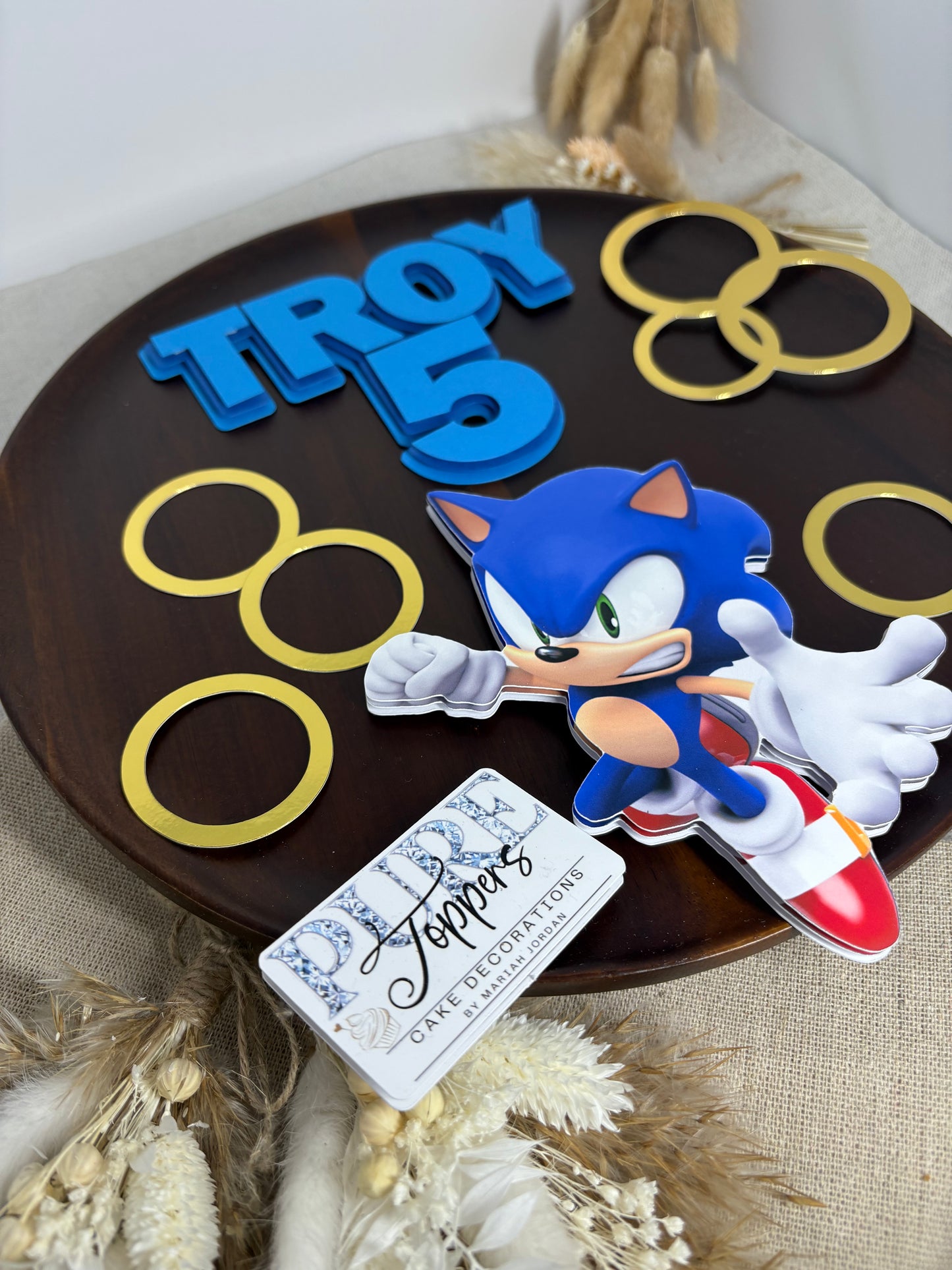 Sonic the Hedgehog cake topper on a decorative plate with gold rings and