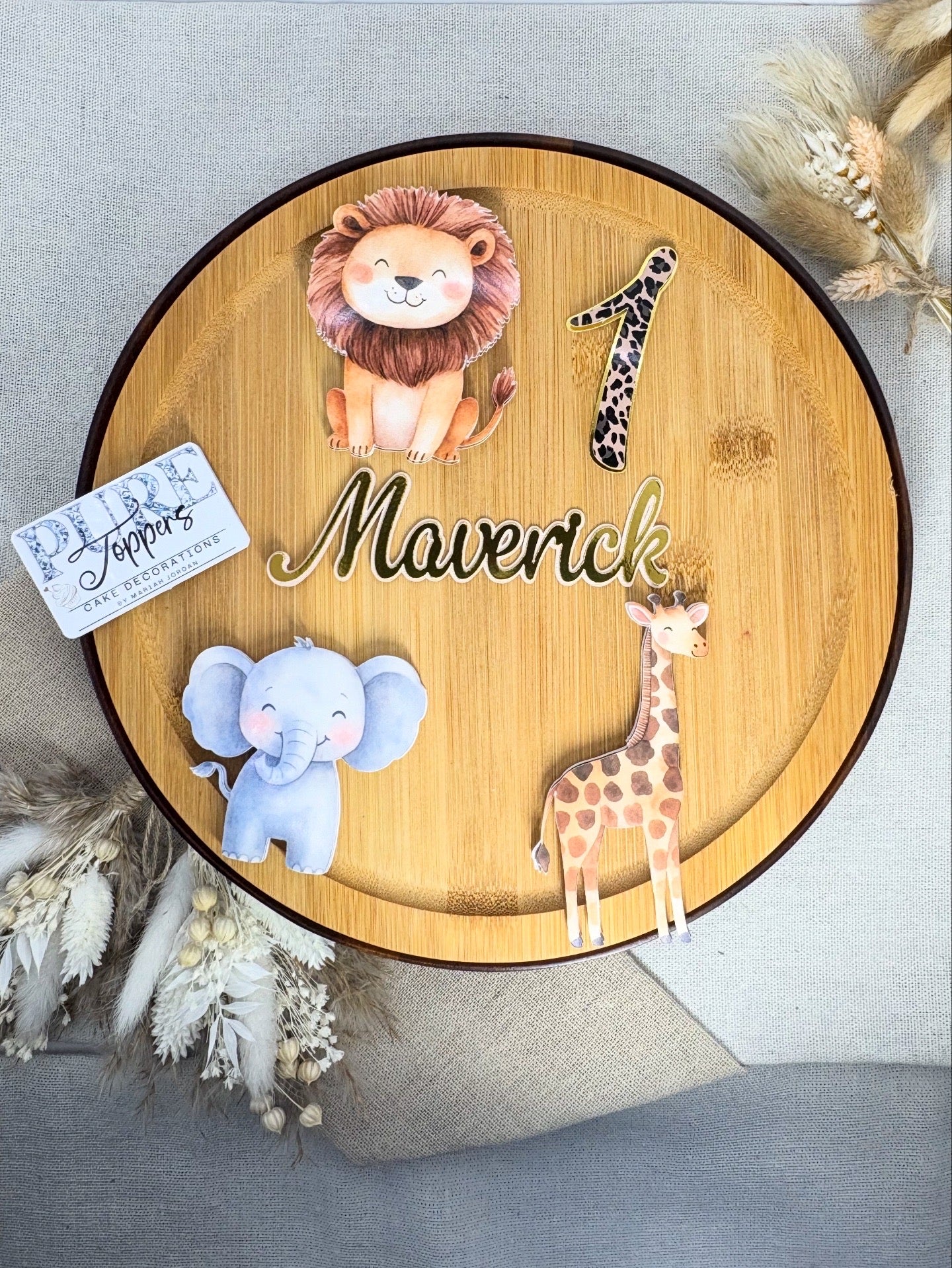Wooden plaque with cartoon lion, elephant, and giraffe illustrations and the name 'Maverick'.