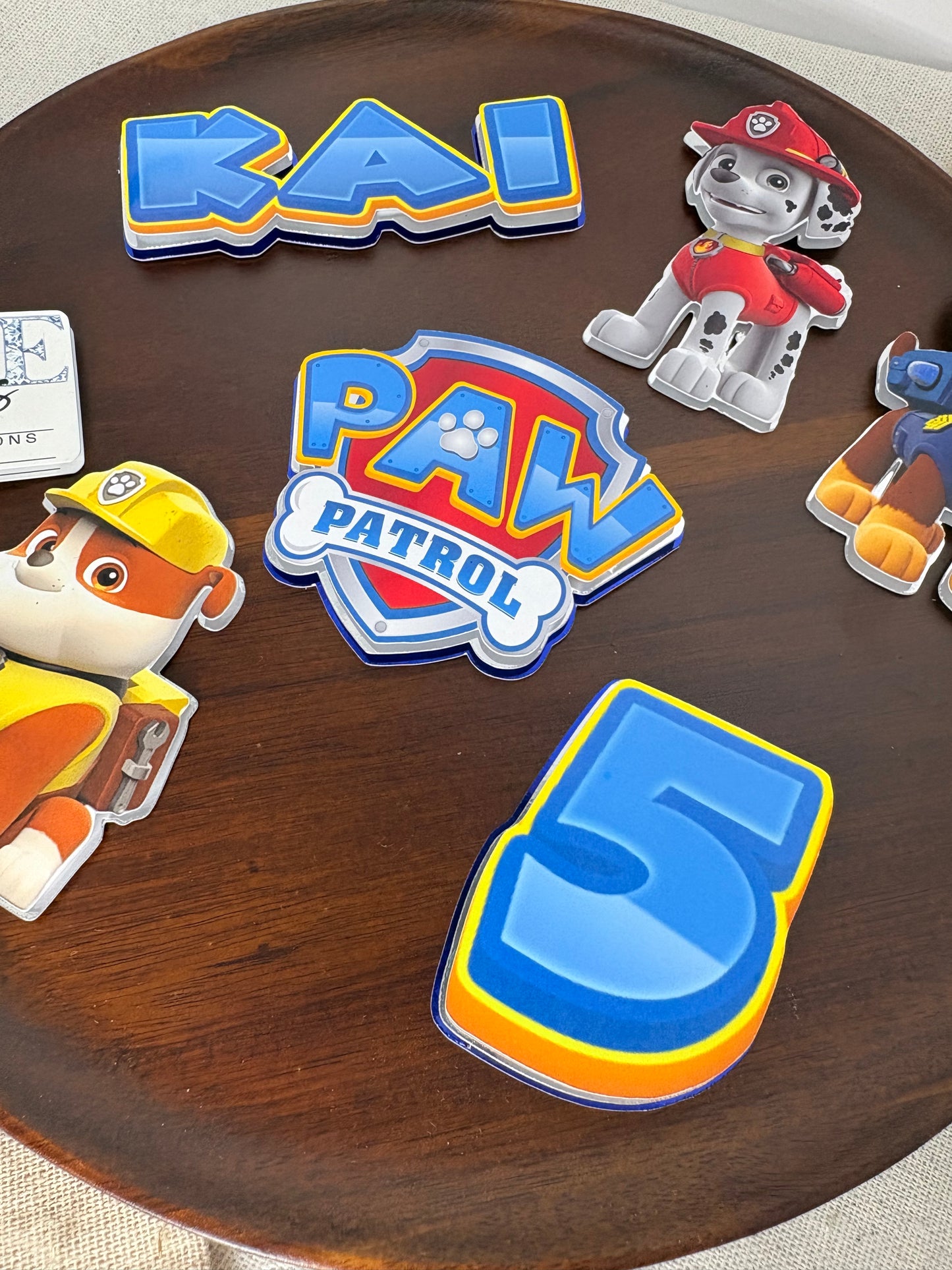 Paw Patrol themed layered cake charms and personalised birthday decorations
