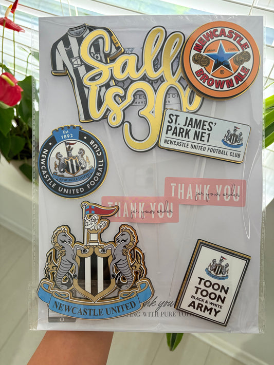 Newcastle United themed cake topper set with layered black and white designs, including personalised name and age, football shirt, club badge, and Newcastle Brown Ale sign.