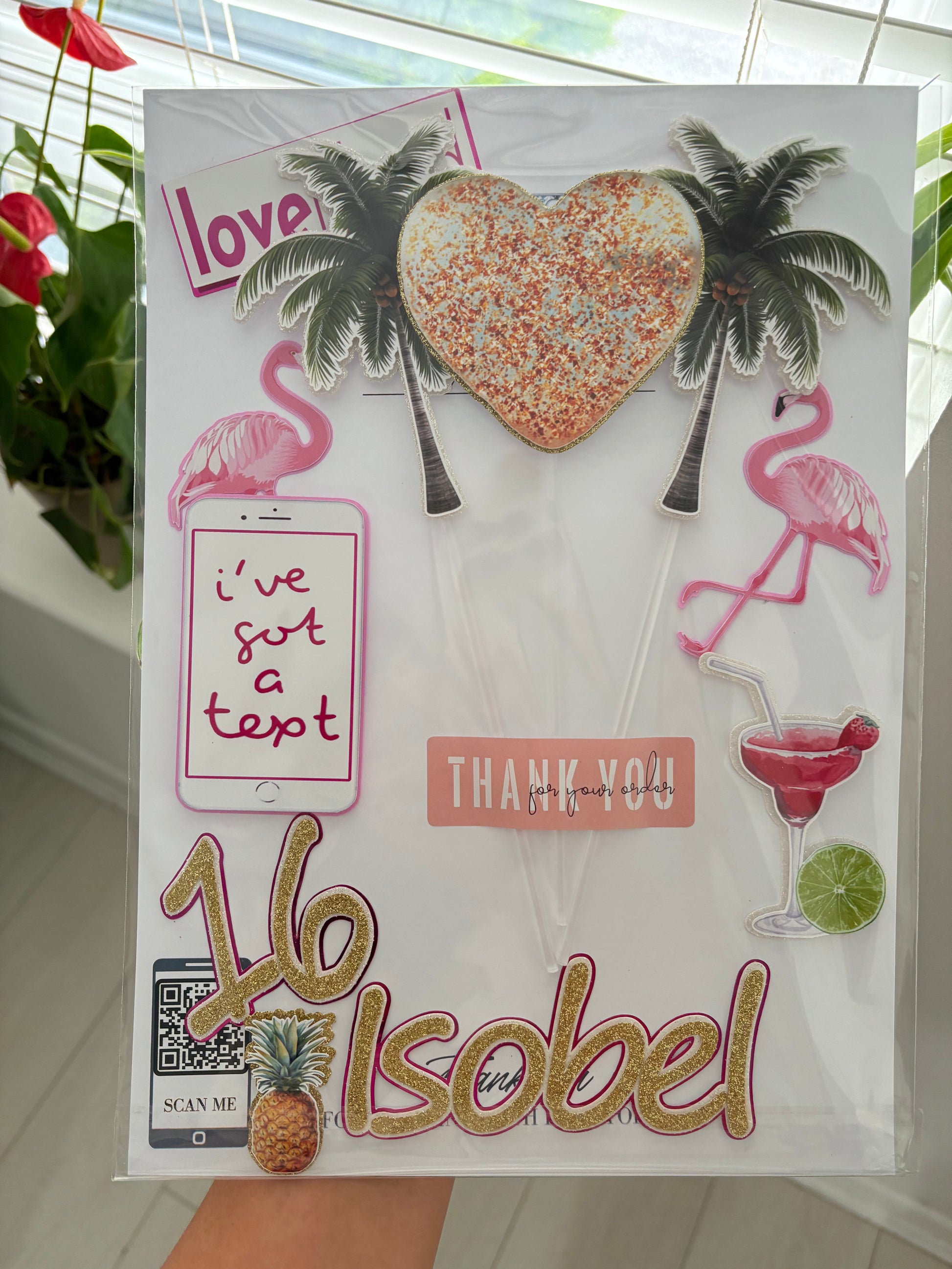 Love Island-themed birthday cake decorated with layered toppers — palm trees, flamingos, and personalised name and age.