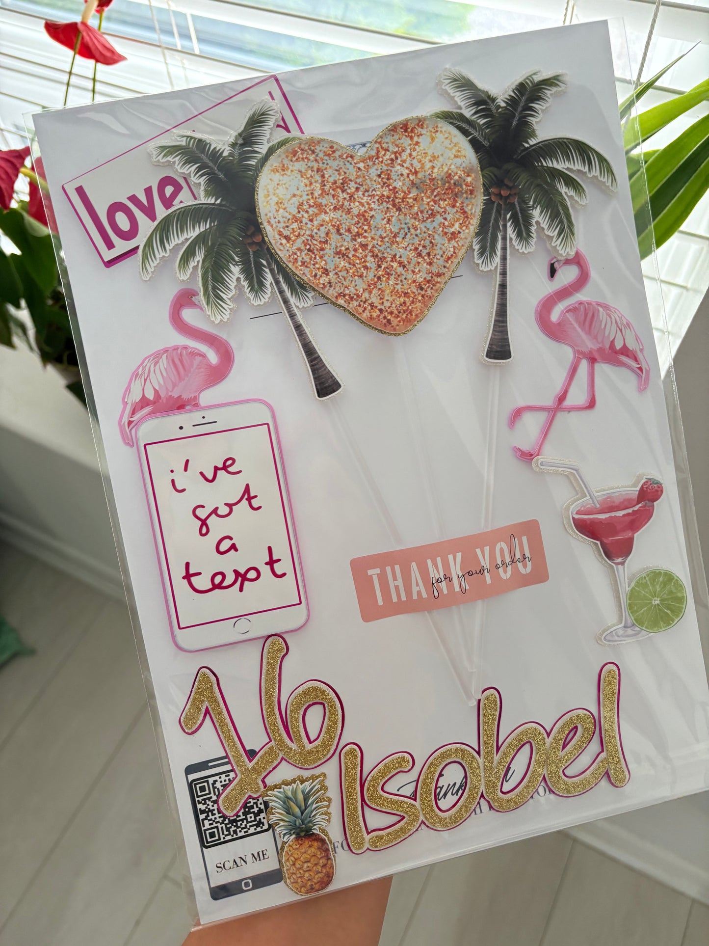 Tropical Love Island cake topper pieces including palm trees, flamingos, phone, Love Island sign, and custom name charm.