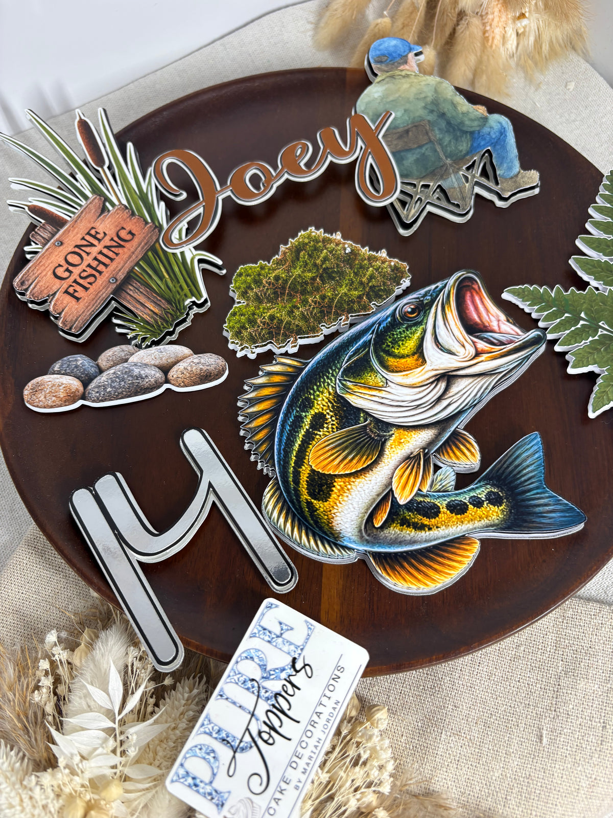Fisherman decoration and rustic Gone Fishing sign for a fishing-themed birthday cake