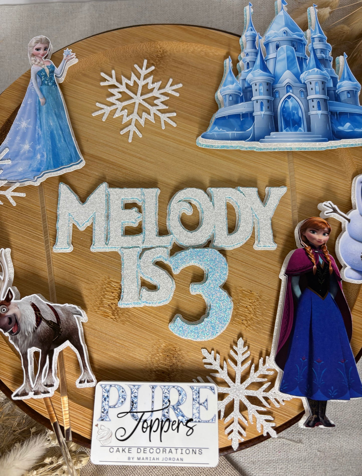 Frozen inspired birthday cake decorations with princess characters, snowman, reindeer and ice castle