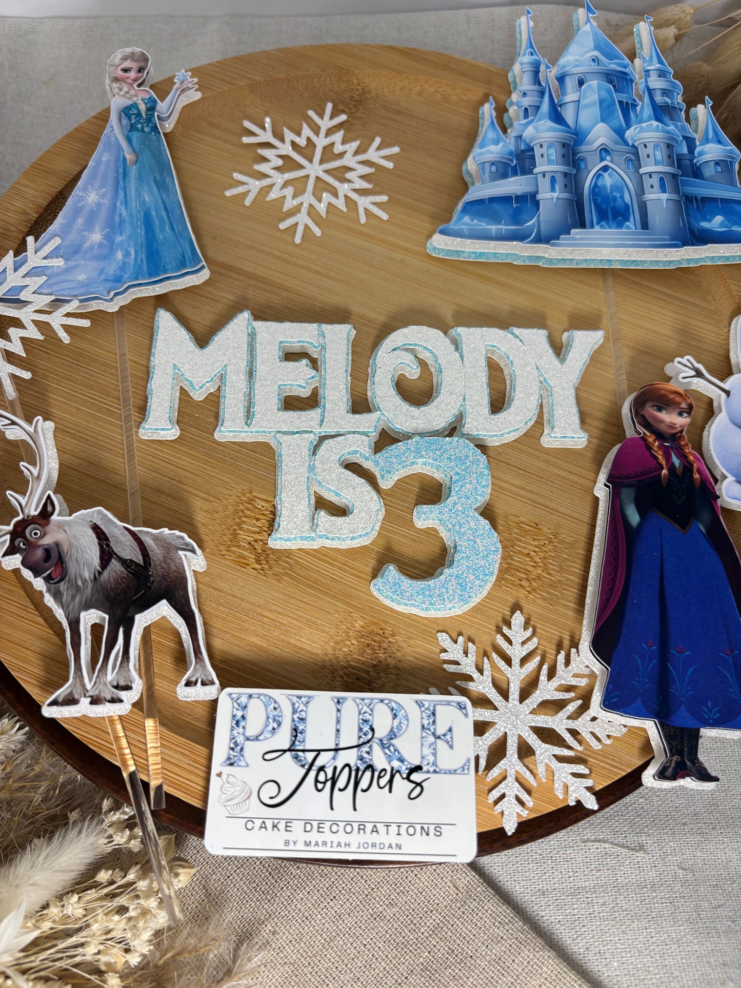 Frozen inspired cake charms with winter characters, castle and icy decorations