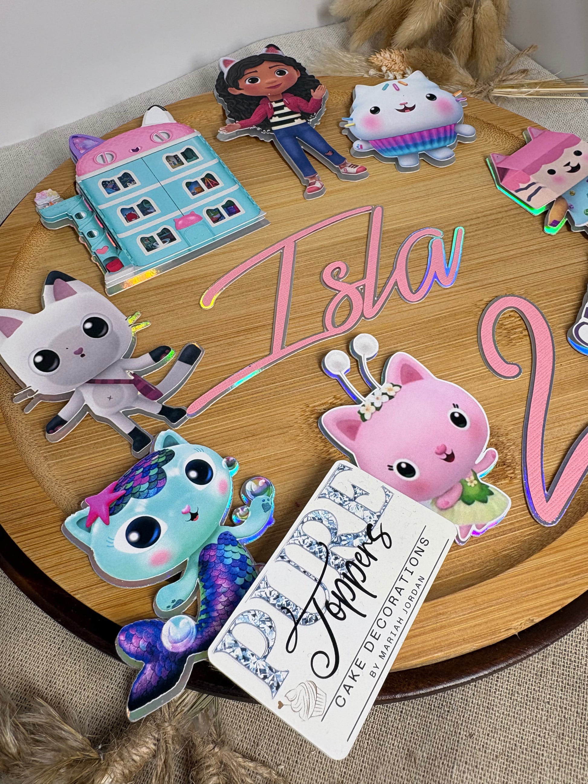 Gabby's Dollhouse birthday cake decorations featuring Gabby and character cake charms