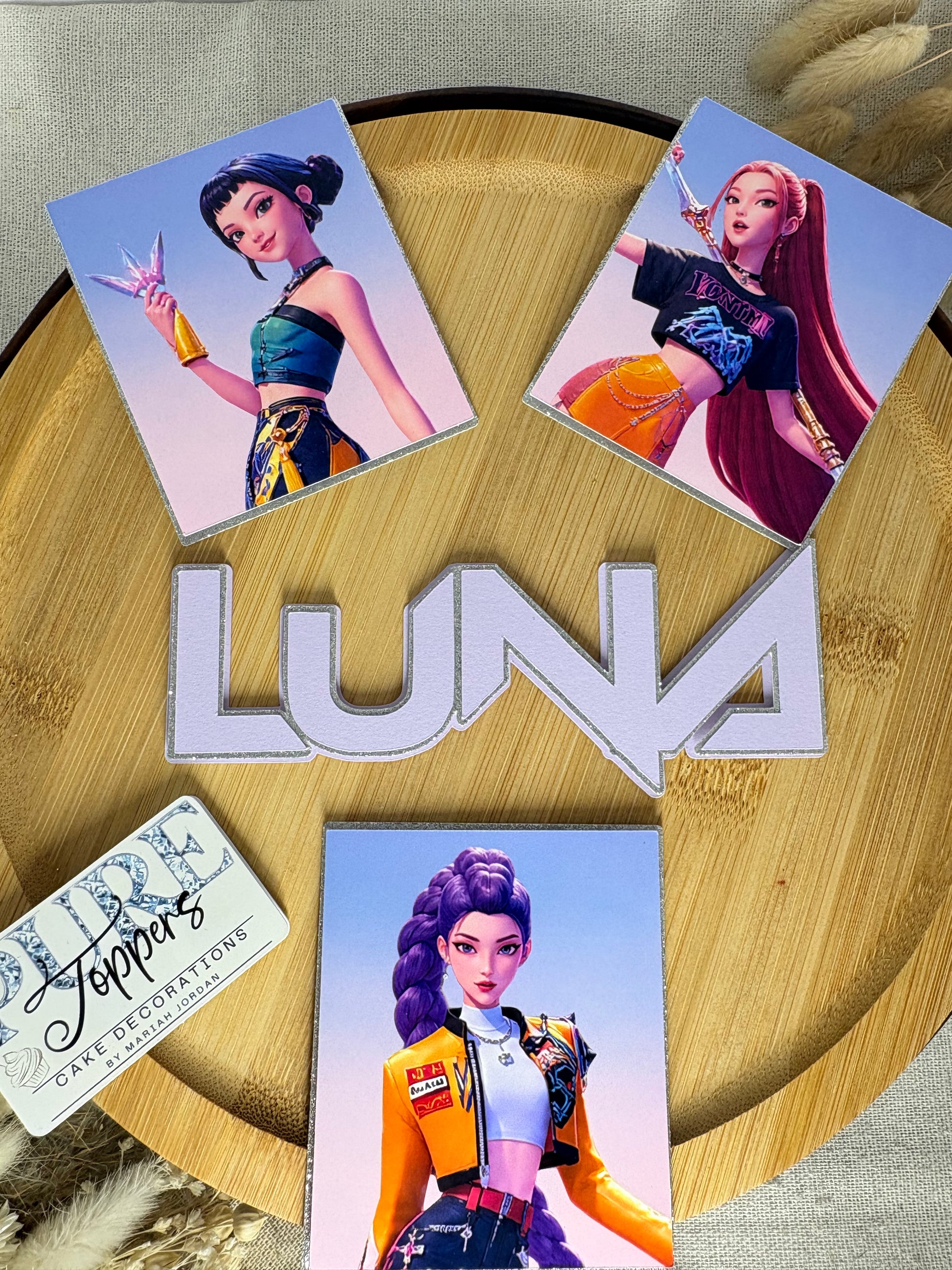 Three framed KPop Demon Hunters character cake charms for birthday cakes