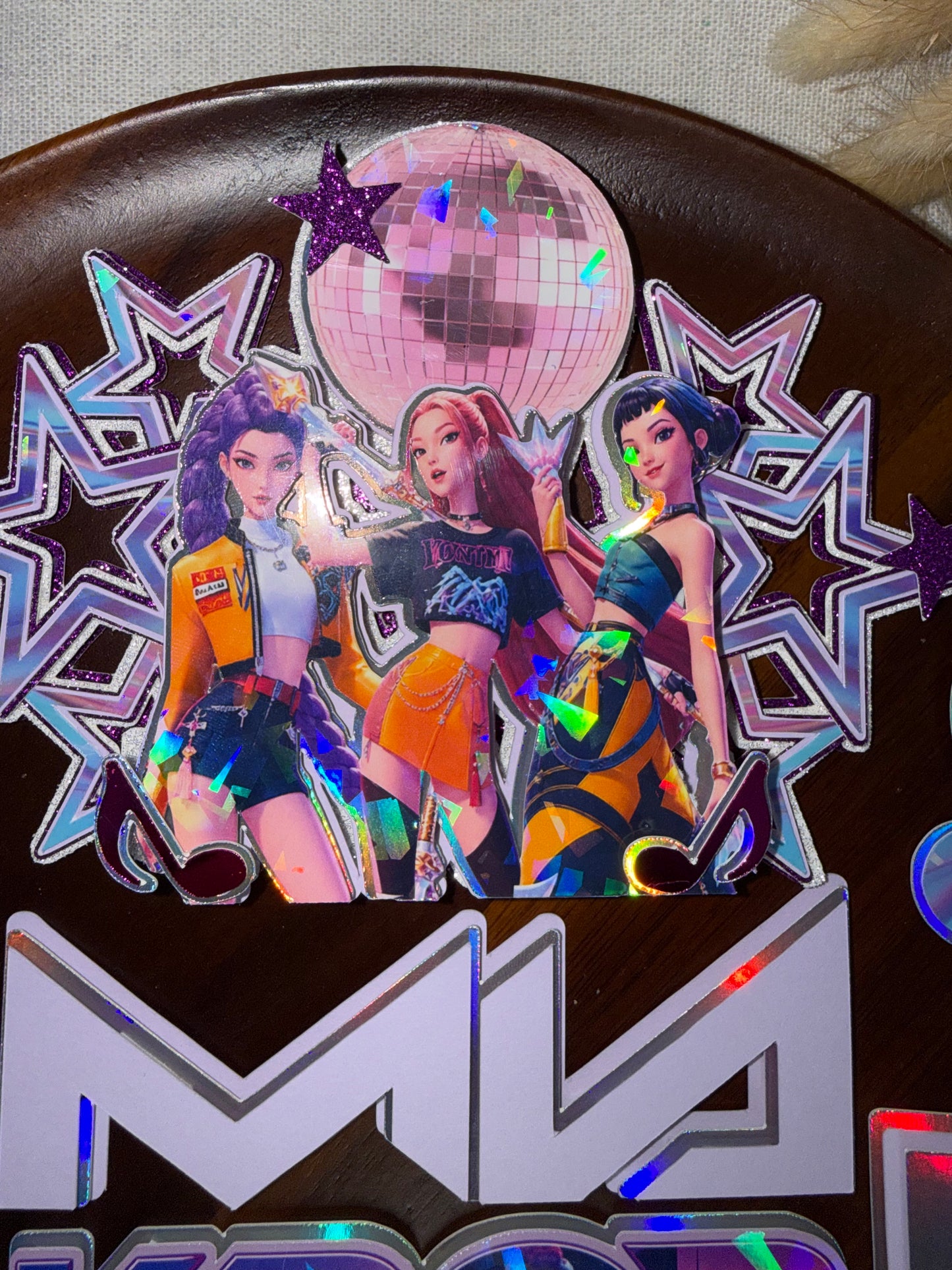 Layered 3D KPop Demon Hunters cake topper with holographic detailing