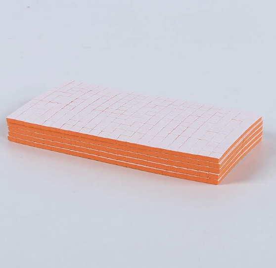 Pre-cut double sided adhesive foam square being peeled from a 3mm foam sheet