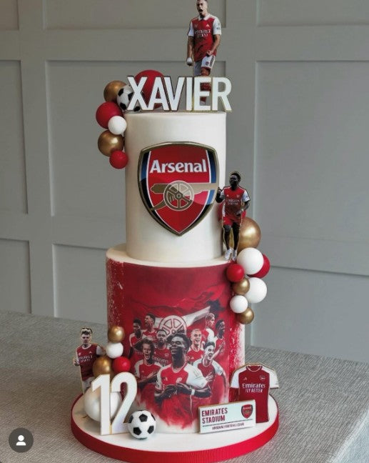 Two-tiered cake with Arsenal FC branding, including a logo and player figures.