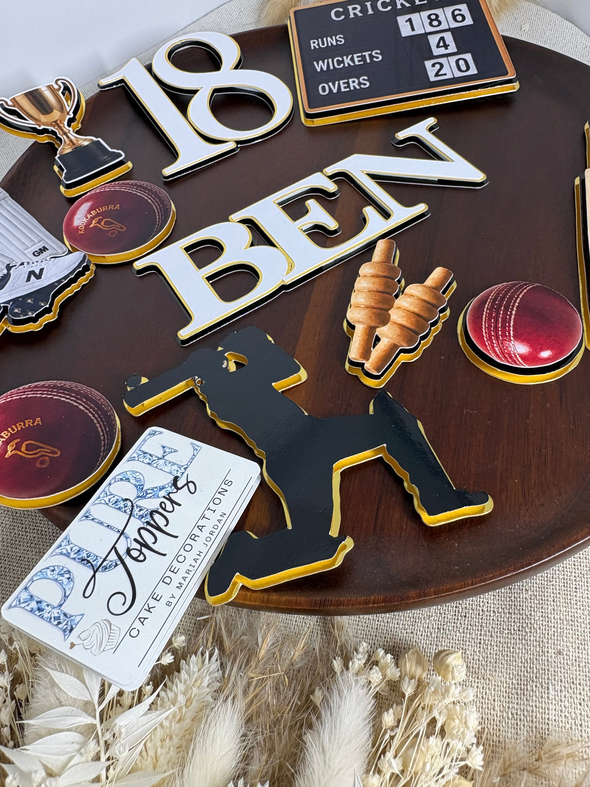 Cricket-themed birthday cake decorated with personalised name, age and coordinating cricket cake toppers