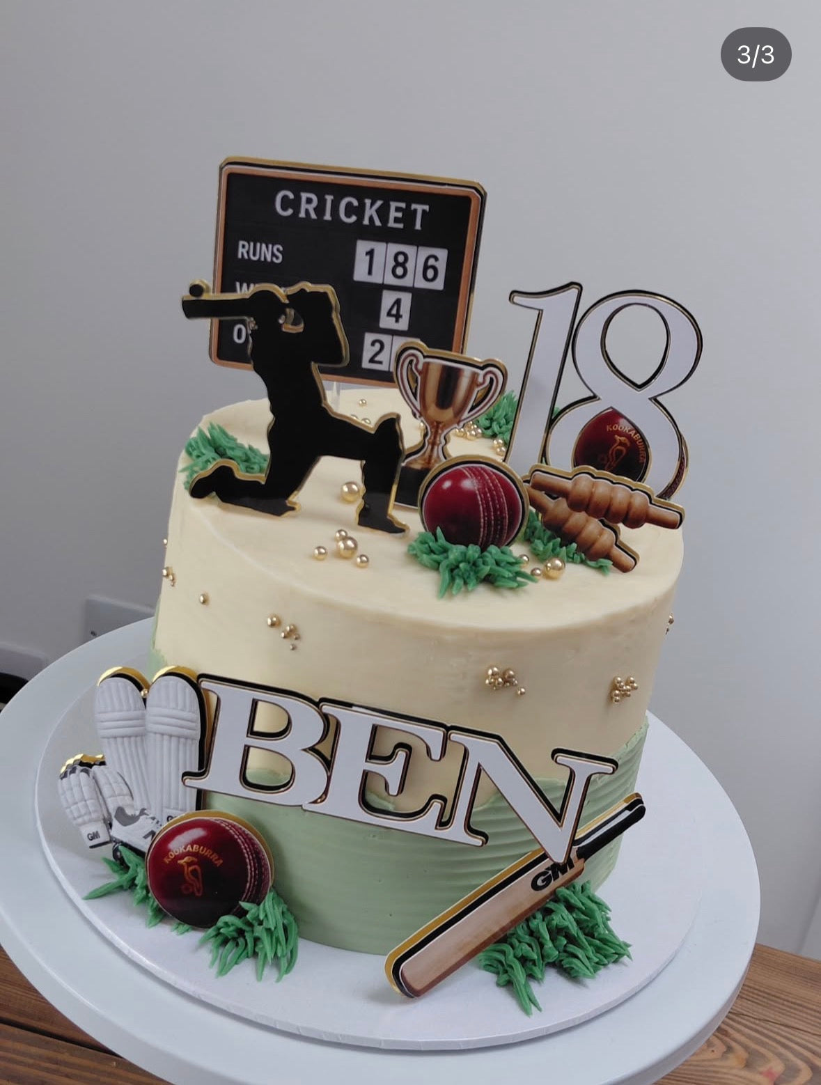 Close-up of personalised cricket cake topper lettering with triple-layered white, black and gold foil details