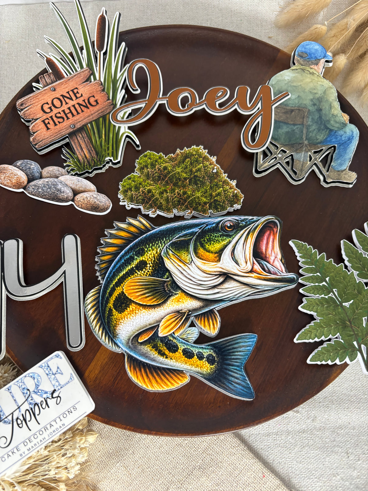 Custom name and age decorations from a personalised fishing birthday cake topper set