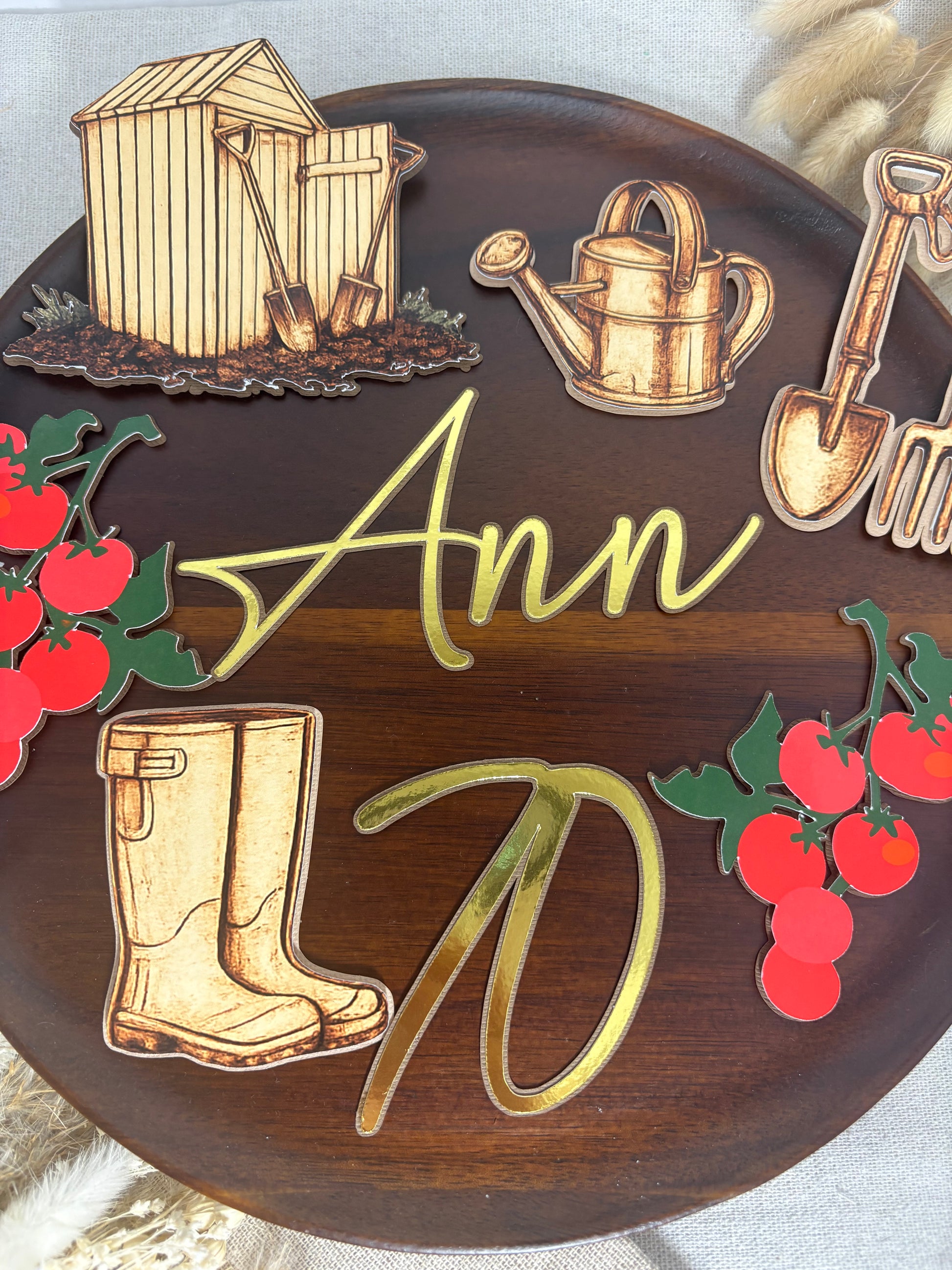 Gardening birthday cake decorations including layered wellies, spade, fork and personalised cake charms.